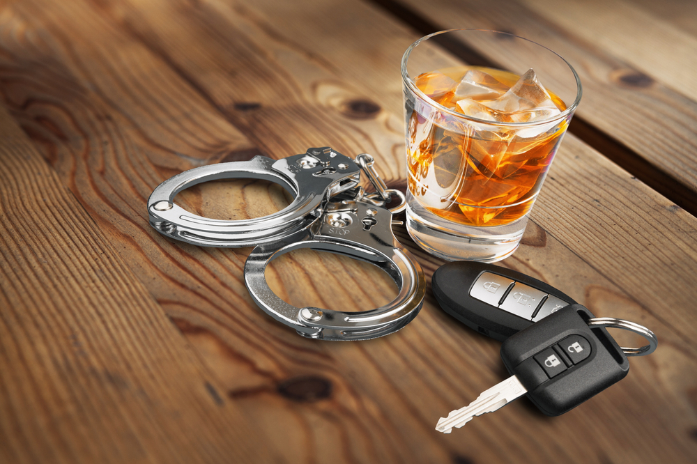 glass of alcohol with handcuffs and keys